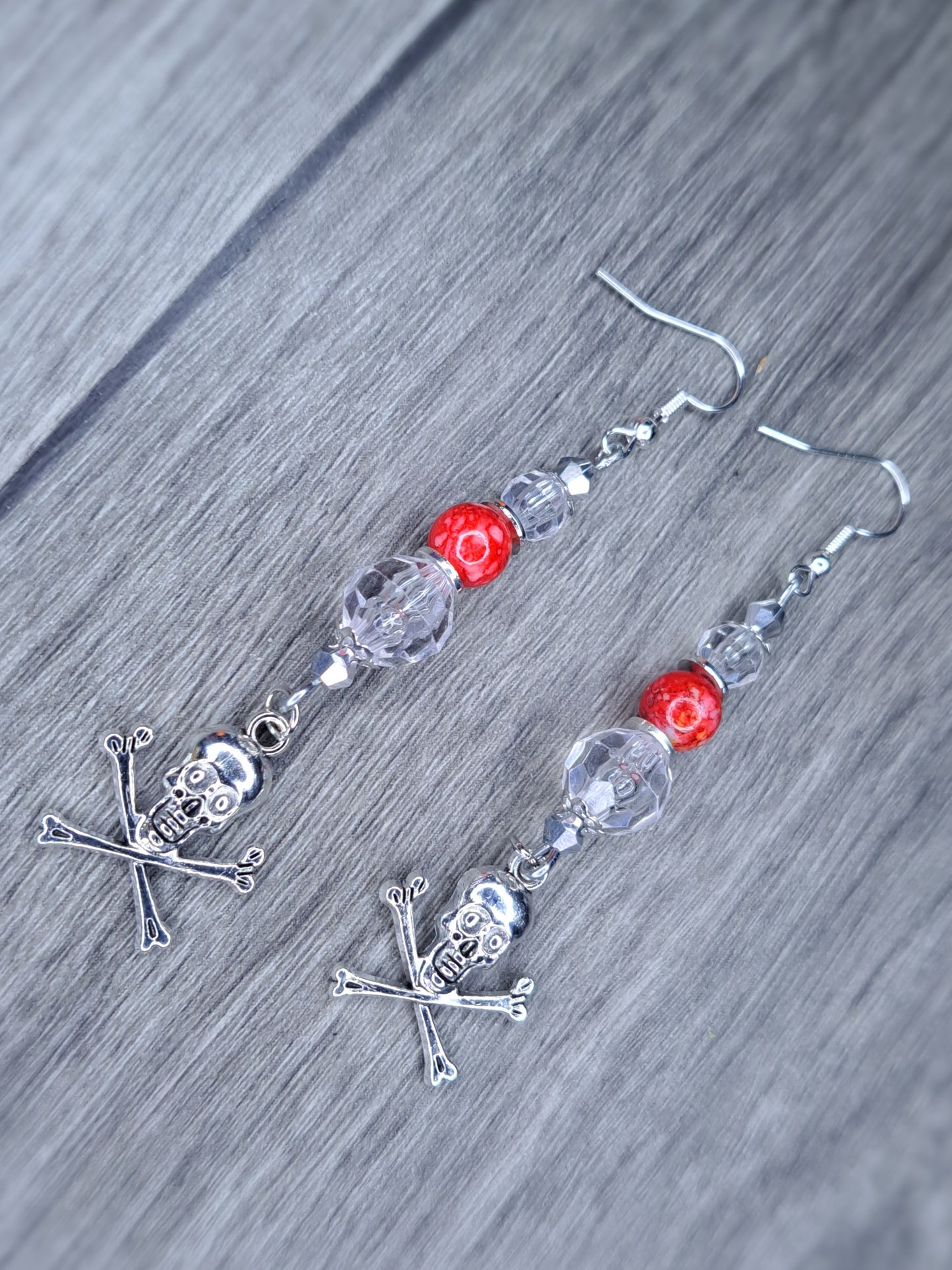 Clear and red beaded stainless steel skull cross bones dangle earrings