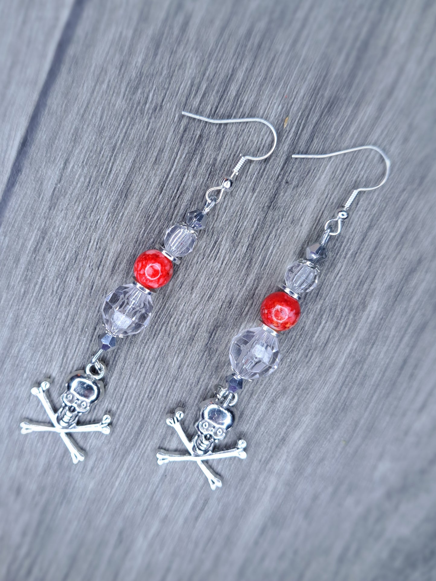 Clear and red beaded stainless steel skull cross bones dangle earrings