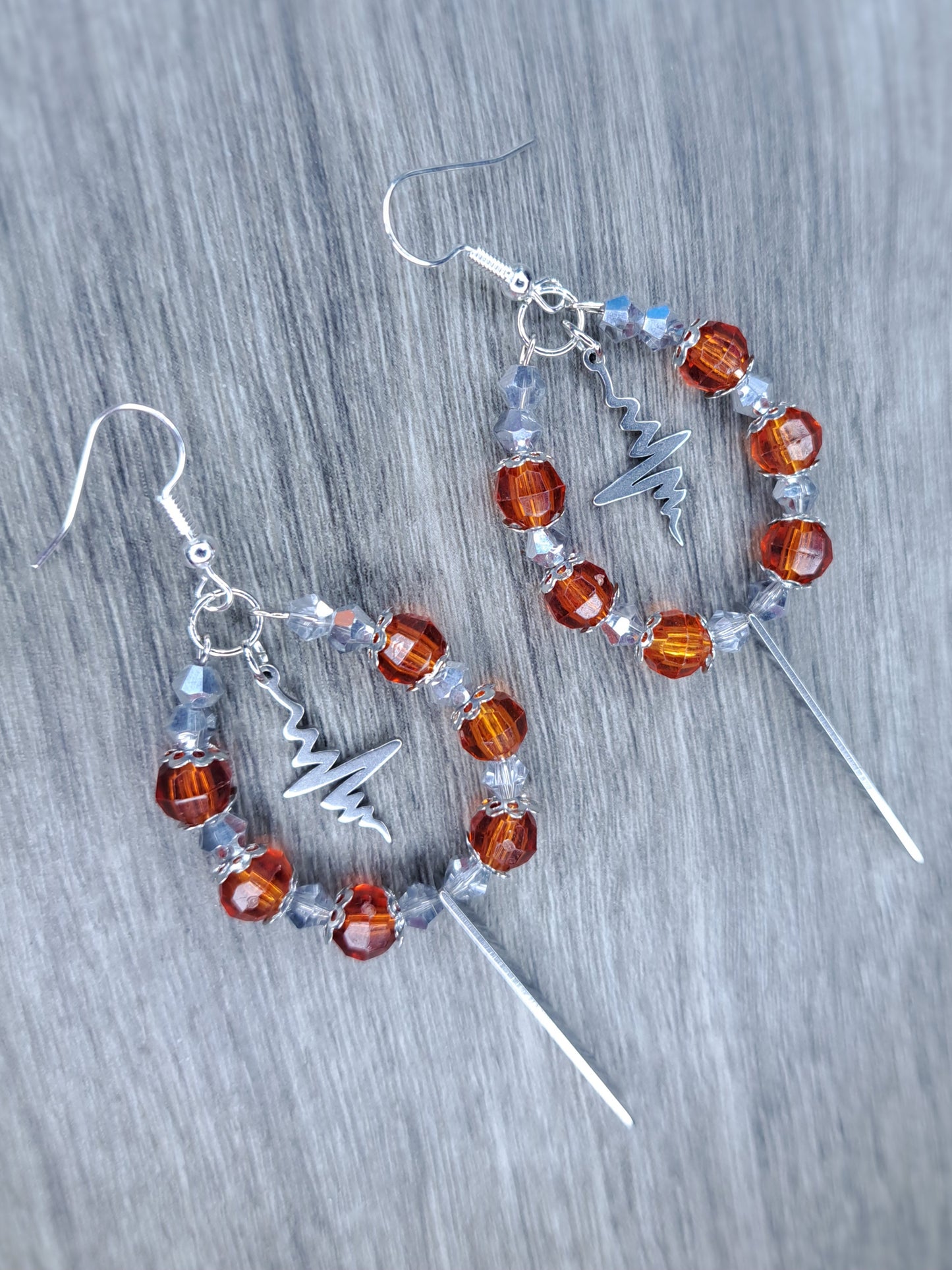 Orange and silver dangly hoop sword earrings