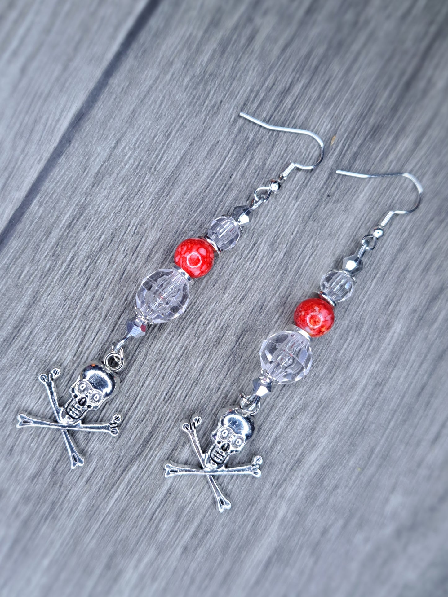 Clear and red beaded stainless steel skull cross bones dangle earrings